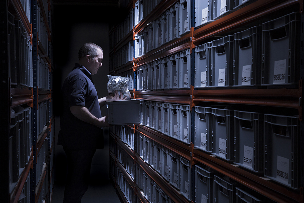 Image of a man in a dramatically lit stock room